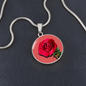 Rose Birth Flower June Graphic Epoxy Disc Necklace. Clear shiny epoxy shows a red petal flower and green stem on a pink background. The jewellery is made of high quality surgical steel or with an 18k gold finish option with an option to engrave a short love you message or special date. Luxury Necklace: 18-22" (45-56cm) adjustable
Circle Pendant: 0.9” x 0.9” (23.5mm x 23.5mm)
