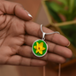 Daffodil Birth Flower March Graphic Epoxy Disc Necklace. Clear shiny epoxy shows a yellow petal flower on a green background. The jewellery is made of high quality surgical steel or with an 18k gold finish option with an option to engrave a short love you message or special date. Luxury Necklace: 18-22" (45-56cm) adjustable
Circle Pendant: 0.9” x 0.9” (23.5mm x 23.5mm)