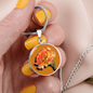 Carnation Birth Flower January Graphic Epoxy Disc Necklace. Clear shiny epoxy shows an orange flower on a green stalk with a darker orange background. The jewellery is made of high quality surgical steel or with an 18k gold finish option with an option to engrave a short love you message or special date. Luxury Necklace: 18-22" (45-56cm) adjustable
Circle Pendant: 0.9” x 0.9” (23.5mm x 23.5mm)
