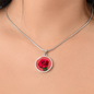 Rose Birth Flower June Graphic Epoxy Disc Necklace. Clear shiny epoxy shows a red petal flower and green stem on a pink background. The jewellery is made of high quality surgical steel or with an 18k gold finish option with an option to engrave a short love you message or special date. Luxury Necklace: 18-22" (45-56cm) adjustable
Circle Pendant: 0.9” x 0.9” (23.5mm x 23.5mm)