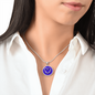 Violet Birth Flower February Graphic Epoxy Disc Necklace. Clear shiny epoxy shows purple and white violets in the shape of a heart on a Purple background. The jewellery is made of high quality surgical steel or with an 18k gold finish option with an option to engrave a short love you message or special date. Luxury Necklace: 18-22" (45-56cm) adjustable
Circle Pendant: 0.9” x 0.9” (23.5mm x 23.5mm)