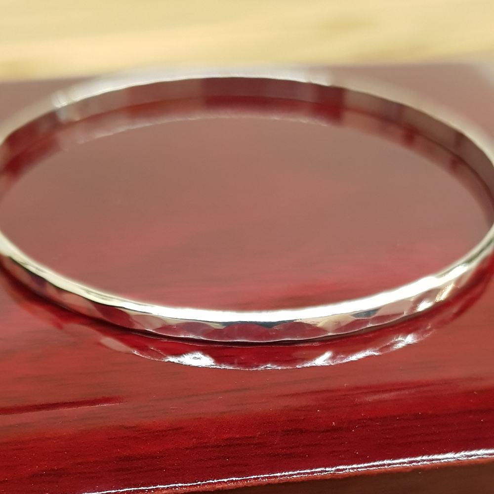 This Beautiful Silver Hammered Bangle is a 3mm wide 3mm wide Hammered Finish D shaped design in 925 silver work with a high polish and looks amazing. The 925 Silver Hammered Bangle is designed to be worn on it's own or added to in multiples. It is 65mm round and slides nicely over the hand.