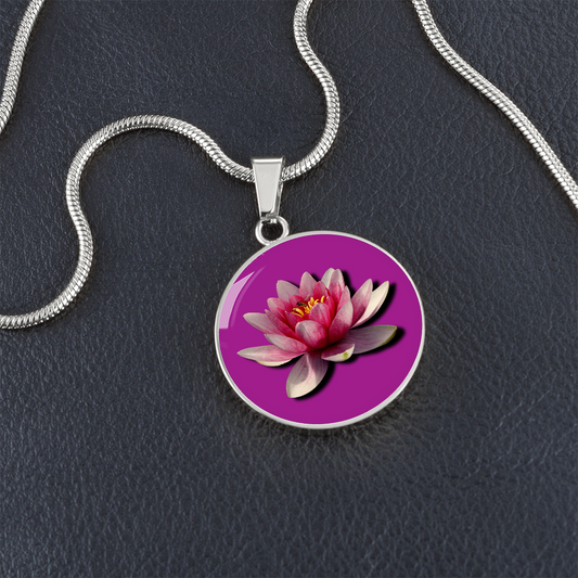 Water Lily Birth Flower July Graphic Epoxy Disc Necklace. Clear shiny epoxy shows a light pink petal flower on a darker pink background. The jewellery is made of high quality surgical steel or with an 18k gold finish option with an option to engrave a short love you message or special date. Luxury Necklace: 18-22" (45-56cm) adjustable
Circle Pendant: 0.9” x 0.9” (23.5mm x 23.5mm)