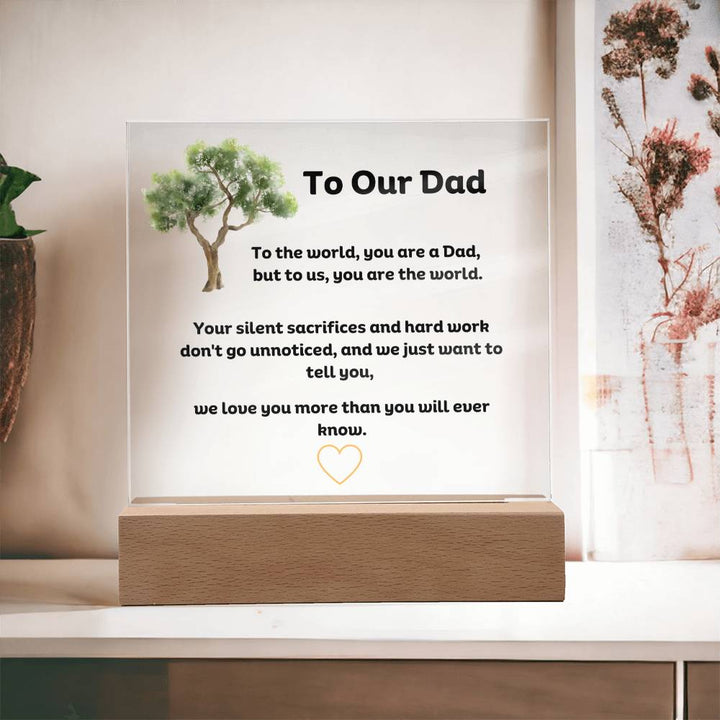 To Our Dad Square Acrylic Plaque With LED Option. Message reads, To the world, you are a Dad, but to us, you are the world. Your silent sacrifices and hard work don't go unnoticed, and we just want to tell you, we love you more than you will ever know.