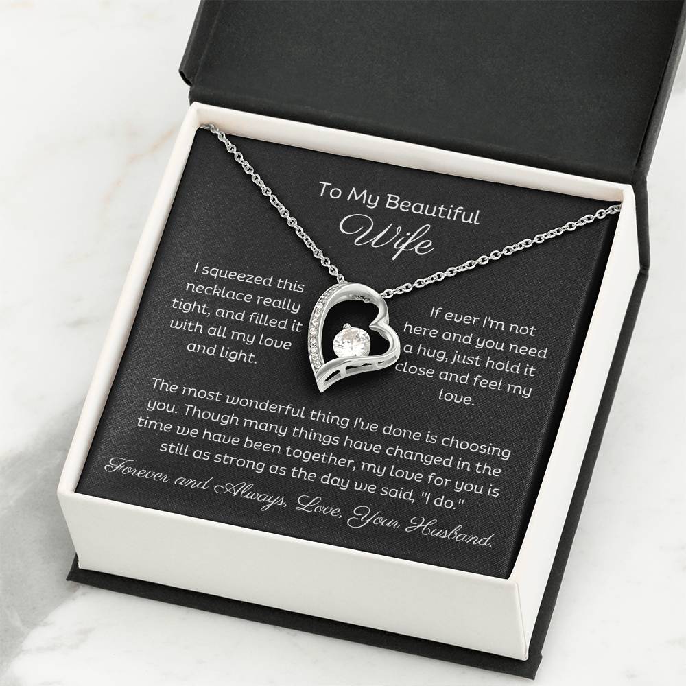Dazzling Forever Love Necklace and heartfelt message card. This necklace features a stunning 6.5mm CZ crystal surrounded by a polished heart pendant embellished with smaller crystals. 14k white gold finish with adjustable chain length: 18" - 22" (45.72cm - 55.88cm)