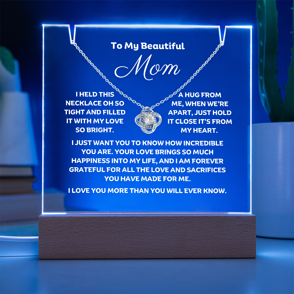 A stunning Square Acrylic and the beautiful Love Knot Necklace for Mom. The beautiful mom heartfelt message is showcased on crystal-clear acrylic, making this set a striking focal point in any space. Paired with the charming Love Knot Necklace.